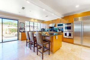 a kitchen with a island with bar stools at Rancho Mirage Tamarisk Villa in Rancho Mirage