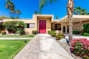 a house with a red door and palm trees at Rancho Mirage Tamarisk Villa in Rancho Mirage