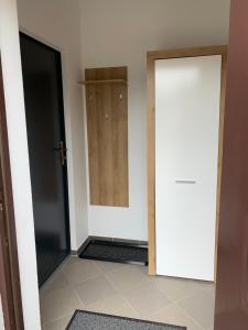 Habitación con 2 puertas y suelo de baldosa. en Apartamenty Stacja en Reszel