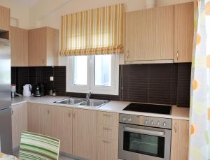 a kitchen with wooden cabinets and a sink and a window at Lemon Tree in Nydri