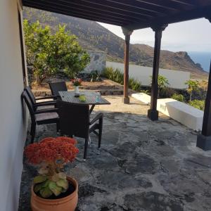 een patio met een tafel en stoelen en uitzicht op de oceaan bij Casa Pardelo in Fuencaliente de la Palma