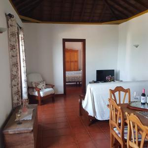 ein Wohnzimmer mit einem Tisch und ein Zimmer mit einem Bett in der Unterkunft Casa Pardelo in Fuencaliente de la Palma