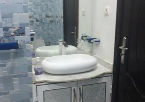 een badkamer met een witte wastafel en een spiegel bij Superbe appartement F3 tout confort in Agadir