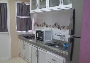 Superbe appartement F3 tout confort في أغادير: مطبخ مع كونتر توب مع ميكروويف