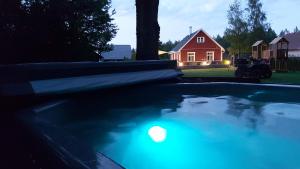 a swimming pool in front of a red house at Hundi puhkemaja in Hiiumaa
