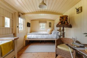 A bed or beds in a room at The Shepherds Huts at Ormesby Manor