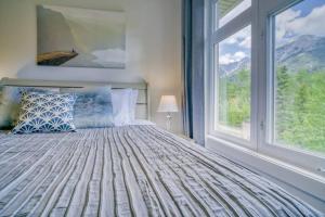 Un dormitorio con una cama y una ventana grande. en Cozy 2 BR - King and Queen Condo Sleep up to 6 for WFH & Vacation, en Canmore