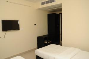 a bedroom with a bed and a flat screen tv at Balaji Residency in Chennai