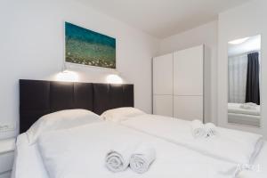 a bedroom with two beds with white sheets at Premium Tartini Apartment by Locap Group in Piran