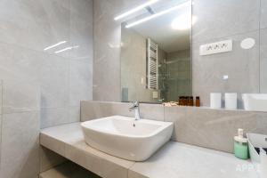 a white bathroom with a sink and a mirror at Premium Tartini Apartment by Locap Group in Piran +29 photos