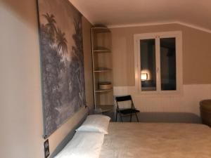 a bedroom with a large painting on the wall at Appartement entre Océan et montagne 15bis avenue de Montbrun Anglet in Anglet