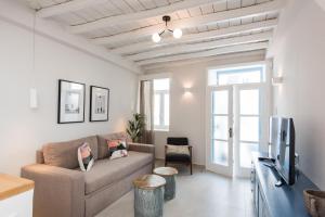 a living room with a couch and a tv at The Mykonos Bougainvillea Townhouse in Mýkonos City