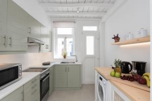 a kitchen with white cabinets and a counter top at The Mykonos Bougainvillea Townhouse in Mýkonos City