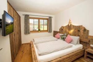 - une chambre avec un lit et une tête de lit en bois dans l'établissement Alpenherz, à Filzmoos