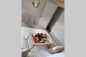 - une chambre avec un lit et un plateau de nourriture dans l'établissement L'Ethnique Chic, à Douai