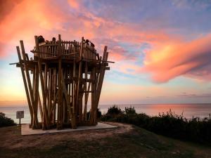 drewniana wieża widokowa na plaży o zachodzie słońca w obiekcie Appartement entre Océan et montagne 15bis avenue de Montbrun Anglet w mieście Anglet