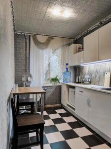 a kitchen with a table and a checkered floor at Смарт квартира на победе in Dnipro