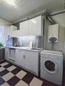 cocina con lavadora y fregadero en Смарт квартира на победе, en Dnipro