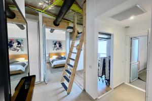 a bedroom with bunk beds and a ladder in a room at Yamba יםבה באכזיב- פנטהאוז חדש ומפנק in Nahariyya