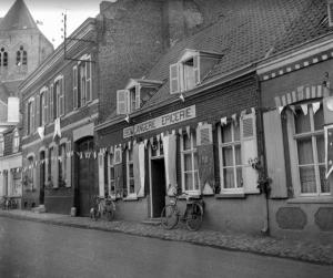 a black and white photo of a building with bikes parked outside at L'Escale in Esquelbecq