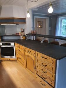 a kitchen with a black counter top and wooden cabinets at Tufte kårhus in Övre Kvamme