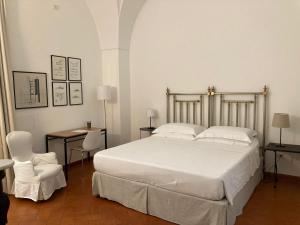 a bedroom with a large white bed and two chairs at Gli Archi e le Stelle in Brindisi