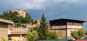 un bâtiment sur une colline avec un château en arrière-plan dans l'établissement La casa di Flora, à Loreto Aprutino