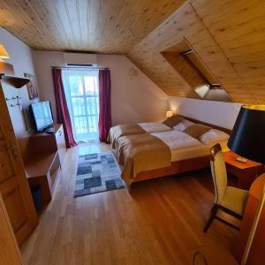 Un dormitorio con una cama grande y una ventana en Ferdinand Penzion, en Moldava nad Bodvou