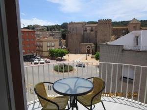 uma varanda com mesa e cadeiras e vista para a cidade em Hotel Gesòria Porta Ferrada em Sant Feliu de Guíxols