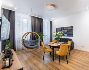 sala de estar con mesa y sillas en Beautiful Cracow Apartments by Cozyplace en Cracovia