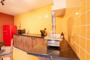 a kitchen with yellow tiles on the wall and a sink at Obidos Rural Chic House in Usseira +49 photos