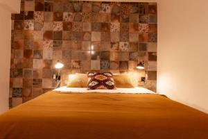 sypialnia z łóżkiem i ścianą wyłożoną kafelkami w obiekcie Obidos Rural Chic House w mieście Usseira