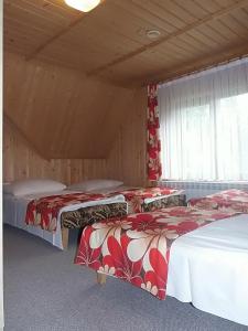 a room with two beds in a wooden cabin at U Justynki in Małe Ciche