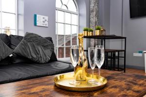 uma mesa com dois copos de vinho e uma garrafa em The Penthouse Gathering - Town Centre - Sleeps Up To 16 em Wrexham