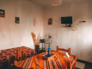 a bedroom with a bed and a table and a television at Altos Valles del Sol in Cafayate