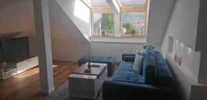 a living room with a blue couch and a tv at Nuage in Sarajevo