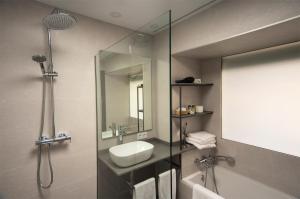 a bathroom with a sink and a shower with a mirror at Hotel La Posada De Paco - Spa & Adults Friendly in San José