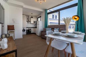 a kitchen and living room with a white table and chairs at LUXURY APARTAMENTOS Doña Bella in Ayamonte