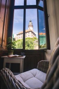 a view of a building from a window with a chair at Downtown Apartments in Český Krumlov