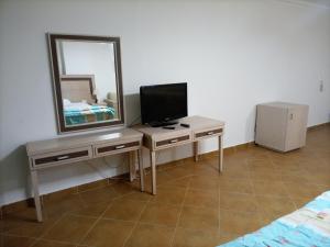 1 dormitorio con escritorio, espejo y TV en Oasis marsa alam, en Marsa Alam