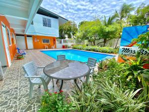 eine Terrasse mit einem Tisch und Stühlen neben einem Pool in der Unterkunft Apartamento Miss Brigida in San Andrés
