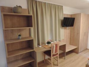 フェンデルスにあるPension Burgschroffenのデスク、テレビが備わる小さな客室です。