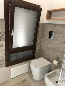 małą łazienkę z toaletą i umywalką w obiekcie B&B Le Mura w mieście Iglesias
