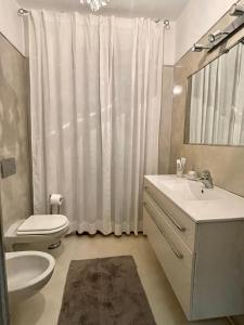 bagno con lavandino, servizi igienici e specchio di Double A Luxury Apartment a Olbia