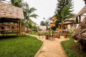 a patio with chairs and a table in a yard at City Villa in Arusha