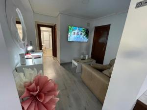 a living room with a couch and a tv on the wall at Villa nueva 1910 in Getxo