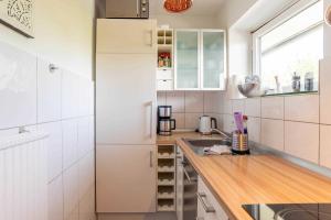 a kitchen with white appliances and a wooden counter top at Ferienwohnung Beachside in Strande
