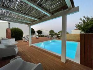 a swimming pool on a deck with a pergola at Dimora Ferralasco in Carloforte