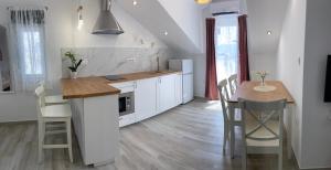 a kitchen with white cabinets and a table with chairs at Villa OpuZEN in Opuzen