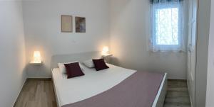 a white bed with two pillows on it in a bedroom at Villa OpuZEN in Opuzen +35 photos